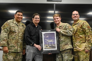 David Pelino, 97th Comptroller Squadron (CPTS) unit program coordinator, center left, is given a retirement gift from members from 97th CPTS at Altus Air Force Base, Oklahoma, May 28, 2025. After 46 years, Pelino retired from civil service on June 6, 2025. (U.S. Air Force photo by Senior Airman Kari Degraffenreed)