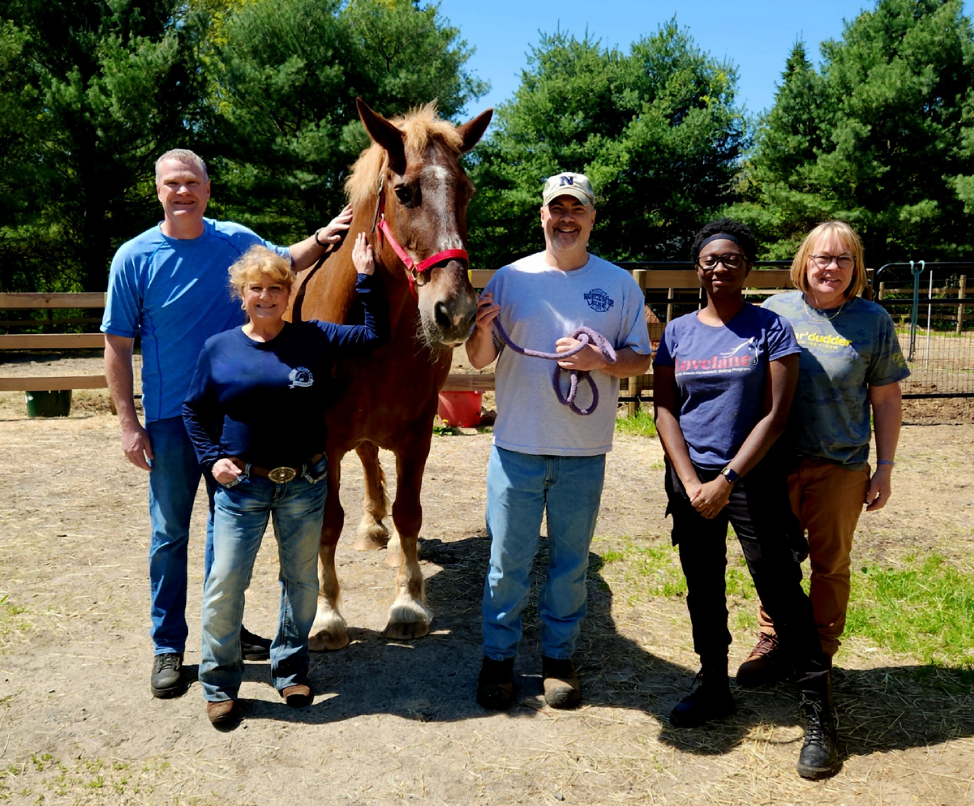 Image of people posing with a horse.