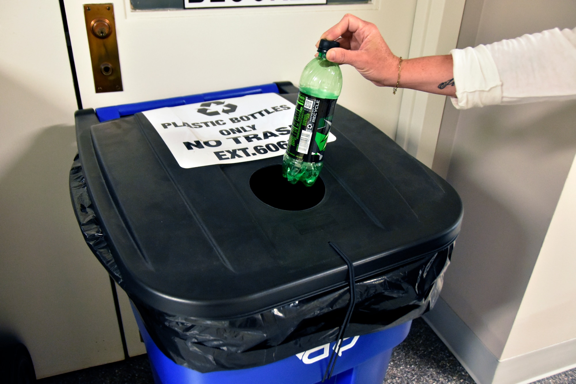 A team member at Arnold Air Force Base, Tenn., places a plastic bottle into one of the plastic recycling bins located throughout the installation May 30, 2025. The Arnold AFB Recycling Center recently announced that beginning June 16 it will no longer accept plastic materials. The move is primarily due to rising costs related to the collection, sorting and processing of recyclable plastics coupled with a reduced market demand for plastic across Tennessee. Other recyclables, such as aluminum cans, cardboard and paper, will still be accepted by the center. (U.S. Air Force photo by Bradley Hicks)