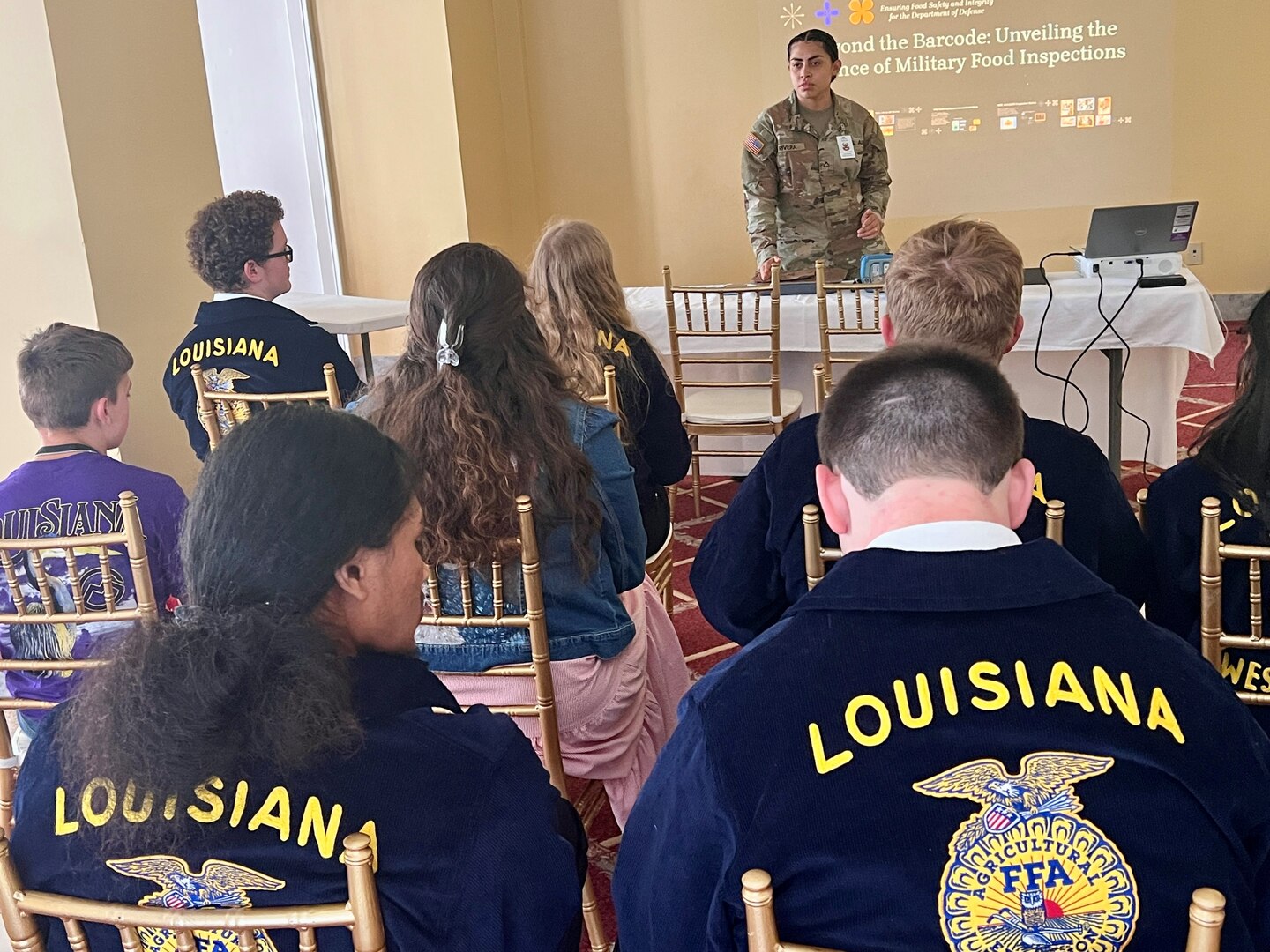 Instructor in uniform stands before a class of students.