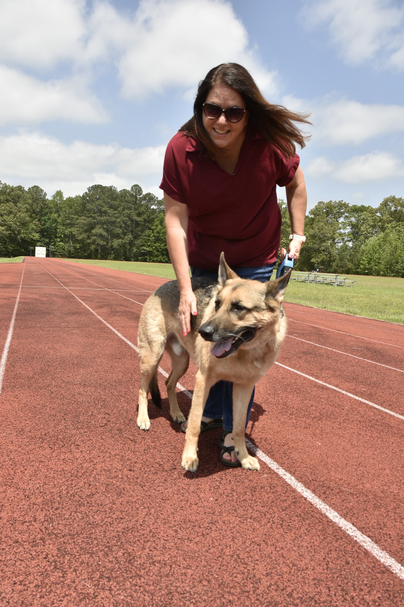 April Carson, Arnold Engineering Development Complex Government Special Access Programs Security Officer, poses for a photo with her dog Titan on May 15, 2025, during the “Operation Pupsicle” event hosted by the AEDC Information Protection Office at Arnold Air Force Base, Tenn., headquarters of AEDC, to coincide with National OPSEC Awareness Month. The AEDC IP team held events throughout May to promote the importance of operations security, more commonly referred to as OPSEC, among the AEDC workforce. (U.S. Air Force photo by Kali Bradford)
