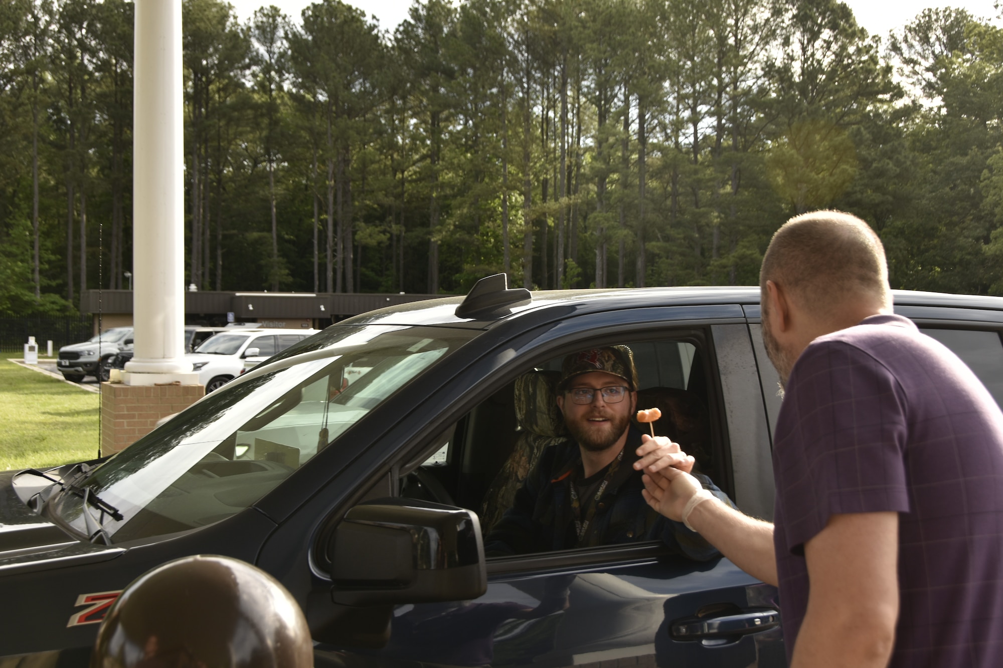 Jared Allen, chief of the Arnold Engineering Development Complex Information Protection Office Arnold Air Force Base, Tenn., offers a donut hole to an Arnold AFB entrant during the donut hole giveaway hosted on May 22, 2025, by the AEDC IP Office to coincide with National OPSEC Awareness Month. The AEDC IP team held events throughout May to promote the importance of operations security, more commonly referred to as OPSEC, among the AEDC workforce. Arnold AFB is the headquarters of AEDC. (U.S. Air Force photo by Bradley Hicks)