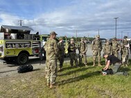 Pfc. Jack Warwick, right, an Alaska Army Guardsman with the Recruit Sustainment Program and emergency firefighter with the Alaska Division of Forestry, demonstrates field gear and speaks to cadets about the similarities between firefighting and military life on Fort Wainwright, Alaska, May 29, 2025. The training was part of the JROTC Cadet Leadership Challenge camp, designed to develop leadership skills, teamwork, and military discipline among cadets.
