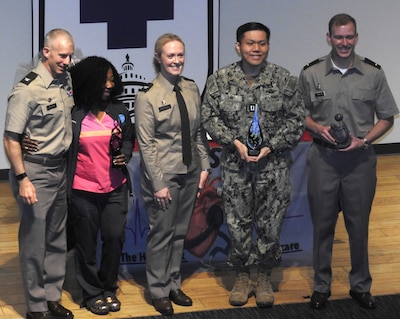 U.S. Army Col. Kenneth Dwyer (left), Commander of the Leader Training Brigade at Fort Jackson, South Carolina, thanks and recognizes members of Walter Reed's nursing team during a recent nurse appreciation and awards program at the medical center.