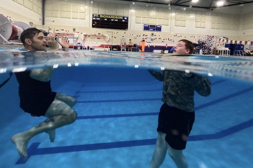 Alaska Army National Guard Sgt. 1st Class Sean Smack, left, a recruiter assigned to the Recruiting and Retention Battalion, treads water with a Junior Reserve Officer Training Corps cadet during water survival training at Joint Base Elmendorf-Richardson, Alaska, May 27, 2025. The training was part of the Junior ROTC Cadet Leadership Challenge camp, designed to develop leadership skills, teamwork, and military discipline among cadets from Dimond, Bartlett, Service, East, West, Colony, and the Bethel Regional high schools. Alaska Army National Guard Recruiting and Retention Battalion personnel served as safety observers and mentors, providing guidance, and sharing their expertise to enhance the cadets’ training experience.