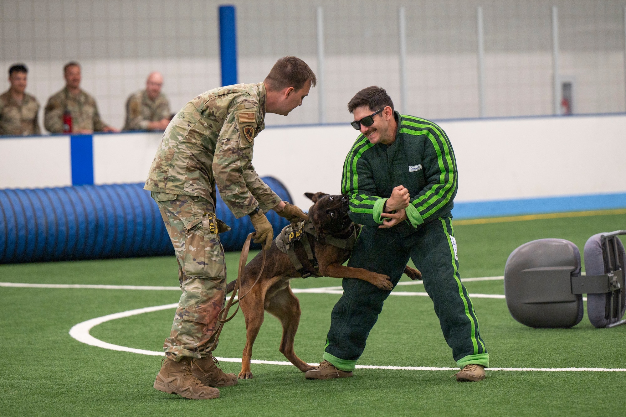 Senior Airman Ryan Faulk, 5th Security Forces Squadron military working dog handler assigned to Minot Air Force Base, N.D., removes MP, 5th SFS military working dog, as he bites Staff Sgt. Stephen Zimmerman, 319th Security Forces Squadron MWD trainer, during a dog agility course at Grand Forks Air Force Base, N.D., May 13, 2025.