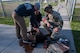 U.S. Army Capt. Joshua Middleton, veterinary corps officer of the Veterinary Readiness Activity assigned to Minot Air Force Base, N.D.; and Staff Sgt. Sally Dolance, animal care specialist of the VRA assigned to Minot AFB, review tactical combat casualty care with U.S. Air Force Staff Sgt. James Edwards, 319th Security Forces Squadron military working dog handler, at Grand Forks Air Force Base, N.D., May 13, 2025.