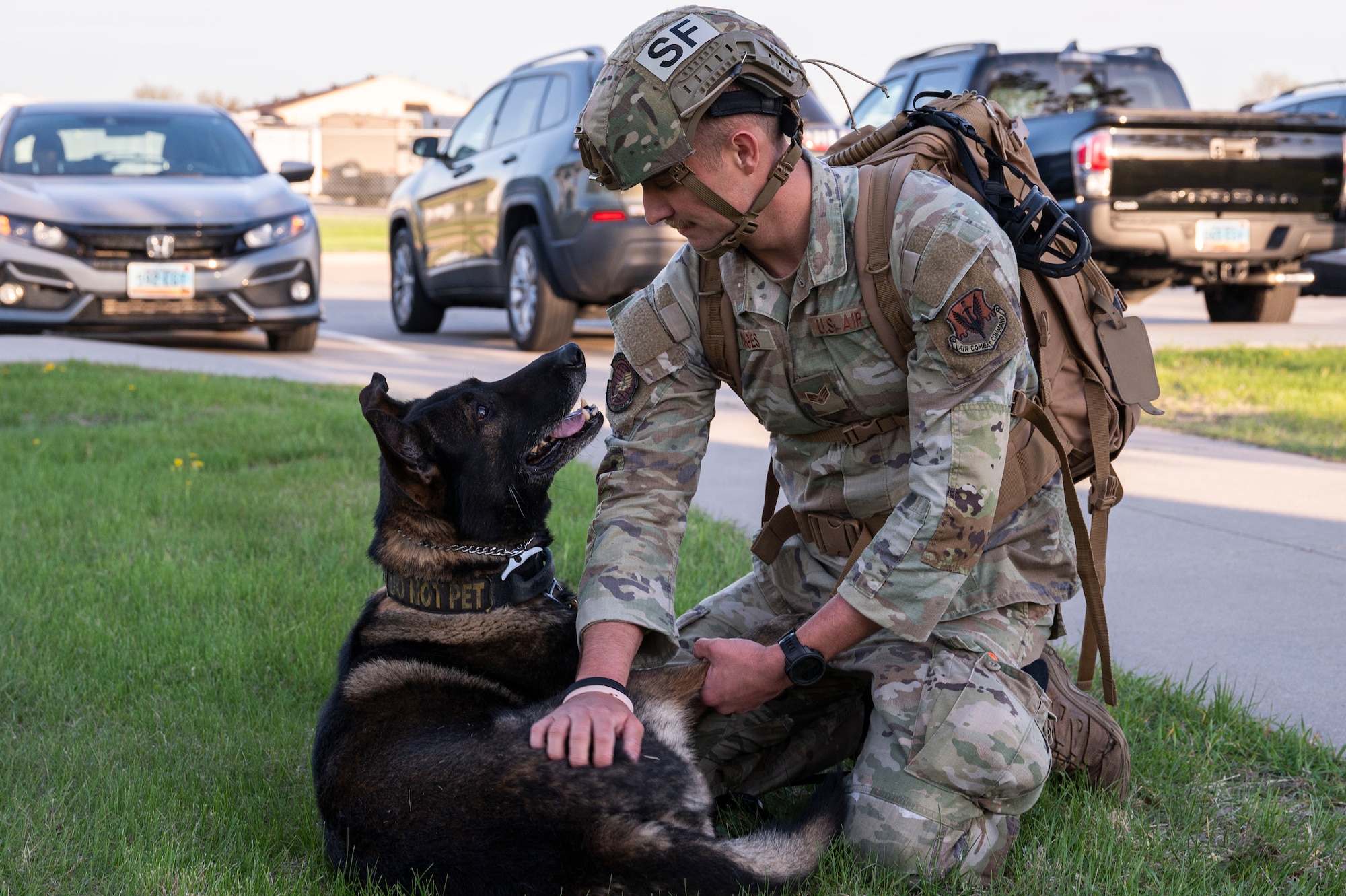 Senior Airman Caleb Manges, 319th Security Forces Squadron military working dog handler, helps Flex, 319th SFS military working dog, stretch before a two-mile ruck run at Grand Forks Air Force Base, N.D., May 13, 2025.