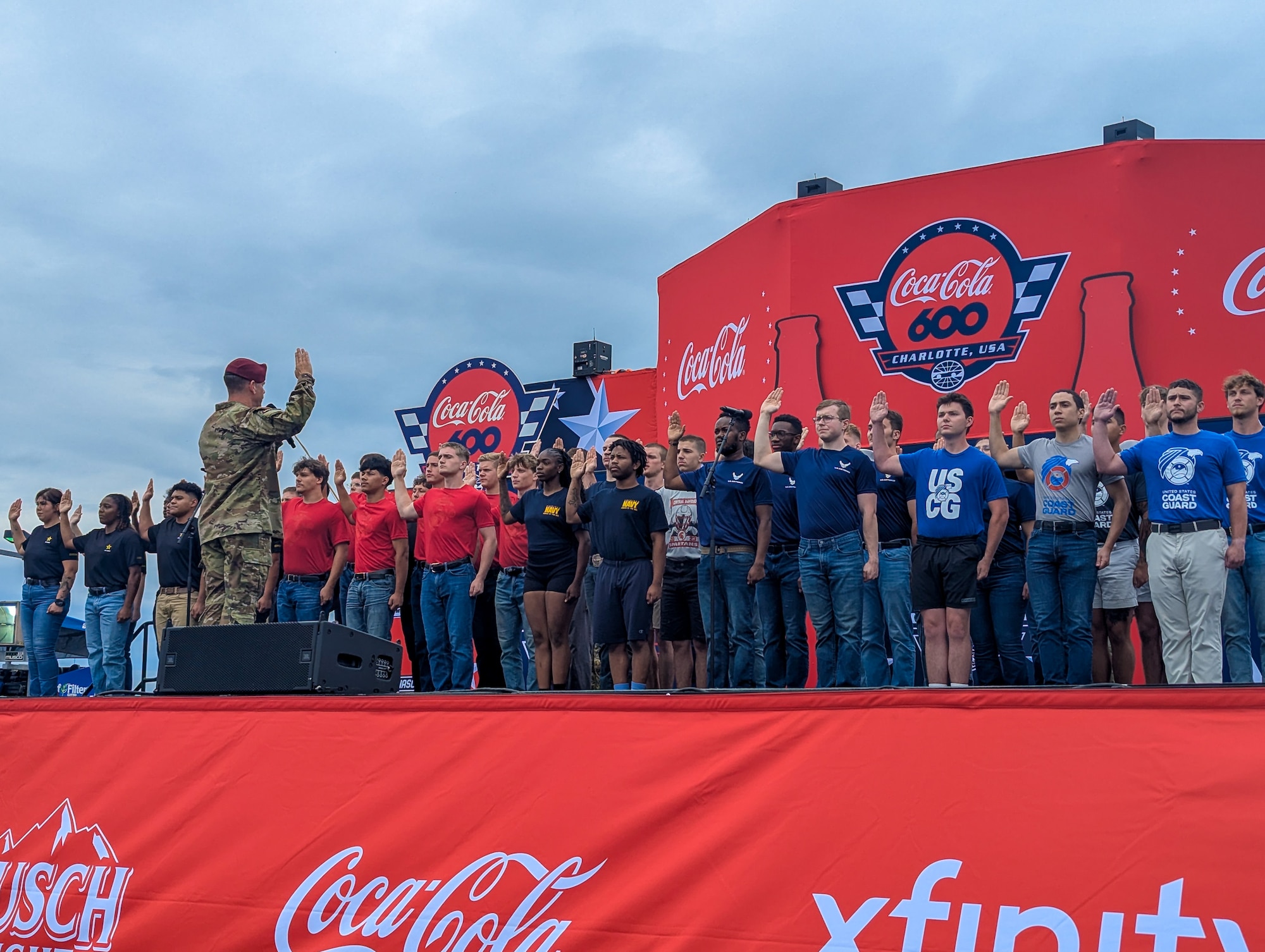 U.S. Army Brig. Gen. John P. Cogbill, XVIII Airborne Corps of Fort Bragg, N.C., administers Oath of Enlistment to 40 recruits as the crowd cheers them on at the Charlotte Motor Speedway, Concord, North Carolina, during the Coca-Cola 600 NASCAR race, May 25, 2025