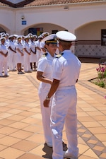 250522-N-FT324-4589. ROTA, SPAIN (May 22, 2025). Captain Michael G. Mercado, Commanding Officer, Navy Medicine Readiness and Training Command Rota, recognizes Lieutenant Nicole E. Jines one of four sailors who achieved an outstanding during the summer whites uniform inspection highlighting excellence in military bearing and professionalism. (U.S. Navy Photo by Mr. Everett Lopez/ Released by Lt. Cmdr. Alicia Sacks)