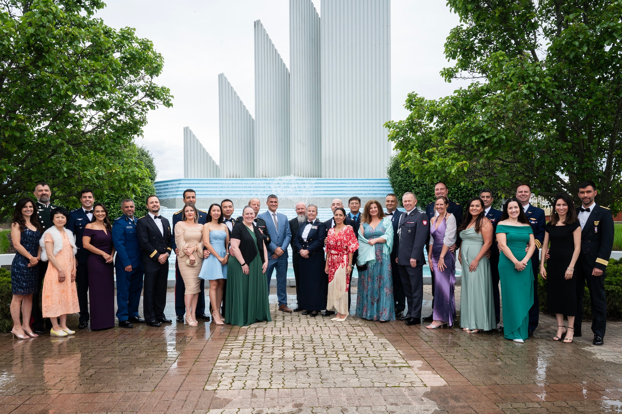 Individuals wearing formal attire pose for photo outside.