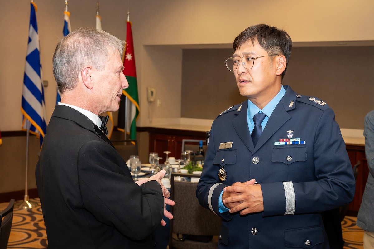 Two men standing, talking.