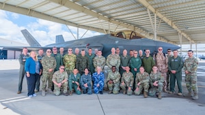 Defense attachés from 17 allied and partner nations and U.S. Air Force Airmen assigned to the 56th Fighter Wing pose for a group photo in front of an F-35A Lightning II during a base visit, June 2, 2025, at Luke Air Force Base, Arizona. The attachés visited Luke AFB to deepen cooperation on F-35 training and integration. The attachés, representing nations from Europe, the Middle East, Asia, and Oceania, received an in-depth look at how the United States and its partners are advancing fifth-generation fighter integration. (U.S. Air Force photo by Senior Airman Elias Carrero)