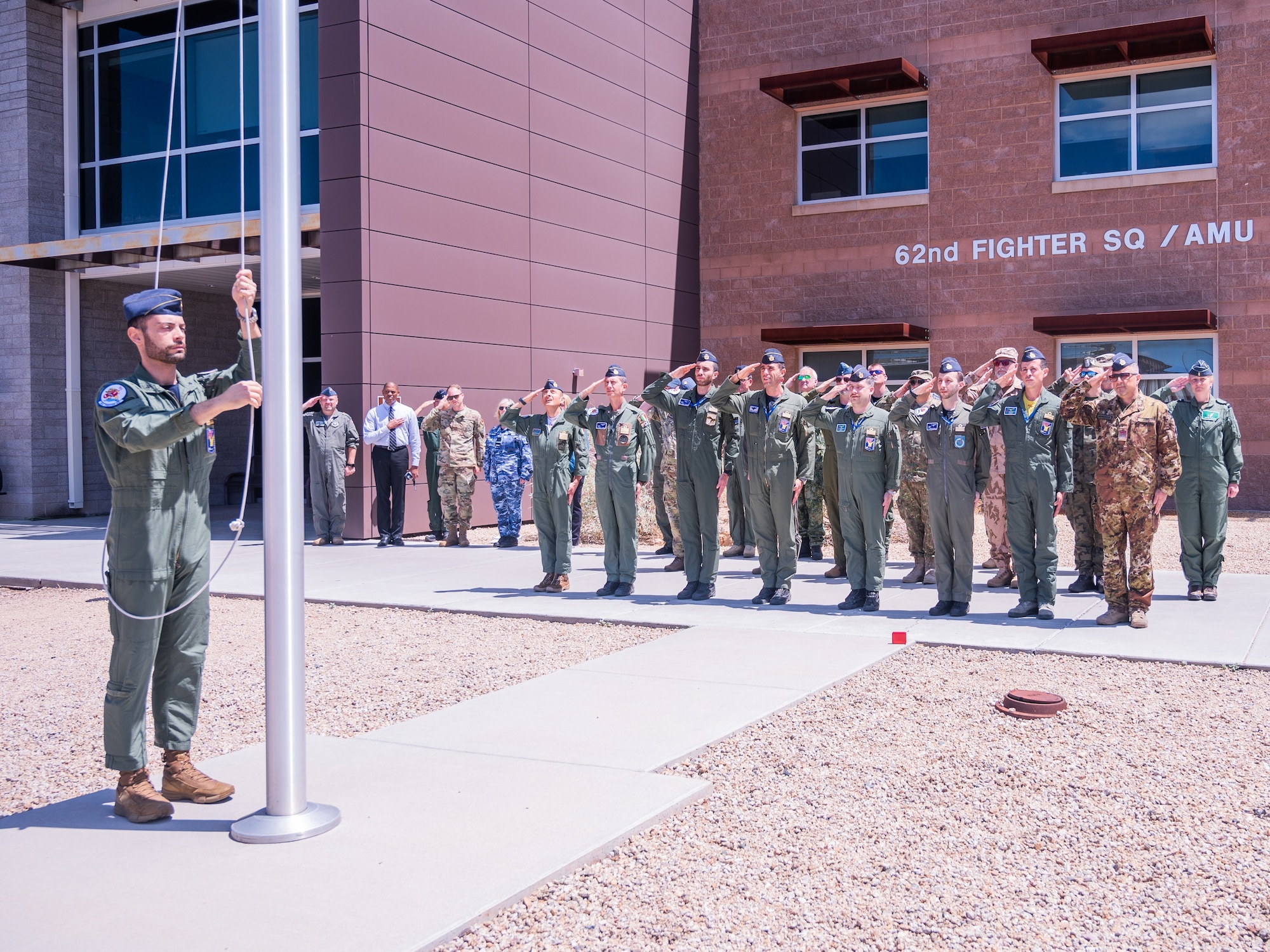 Defense attachés from allied and partner nations and Italian F-35A Lightning II pilots attend an Italian flag raising ceremony during a base visit, June 2, 2025, at Luke Air Force Base, Arizona. June 2 is Italy’s Republic Day, commemorating the 1946 referendum in which Italians voted to transition from a monarchy to a republic. The group of attachés attended a flag raising ceremony in honor of the holiday as a show of respect and solidarity with their Italian counterparts, reinforcing the importance of alliance and mutual recognition among partner nations. (U.S. Air Force photo by Senior Airman Elias Carrero)
