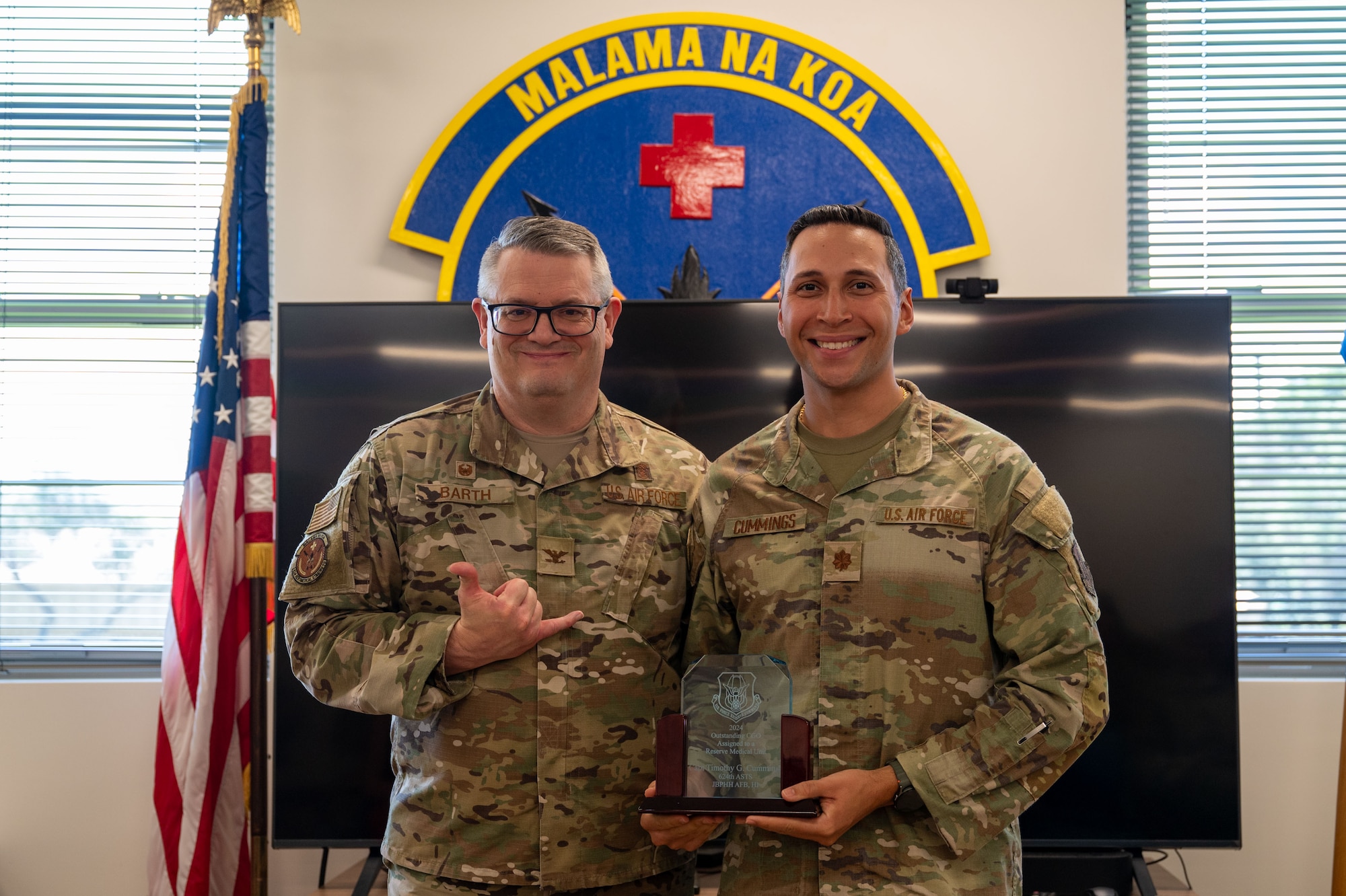 U.S. Air Force Maj. Timothy Cummings, member of the 624th Aeromedical Staging Squadron poses for a photo holding an award at Joint Base Pearl Harbor-Hickam, Hawaii, April 6, 2025.