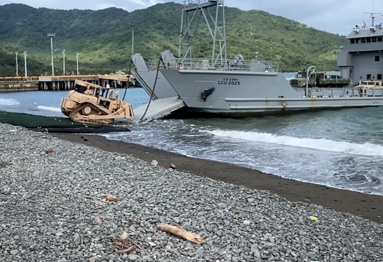 A bottom-mounted undercarriage recovery dozer is offloaded from an Army landing craft utility onto Submersible Matting (SUBMAT) during joint exercise Balikatan 25. The U.S. Army Engineer Research and Development Center’s SUBMAT team supported beach landing operations with in-person engineering and technical guidance of the SUBMAT system during this year’s exercise in Dingalan, Philippines. (U.S. Marine Corps photo by Cpl. Brian Knowles)