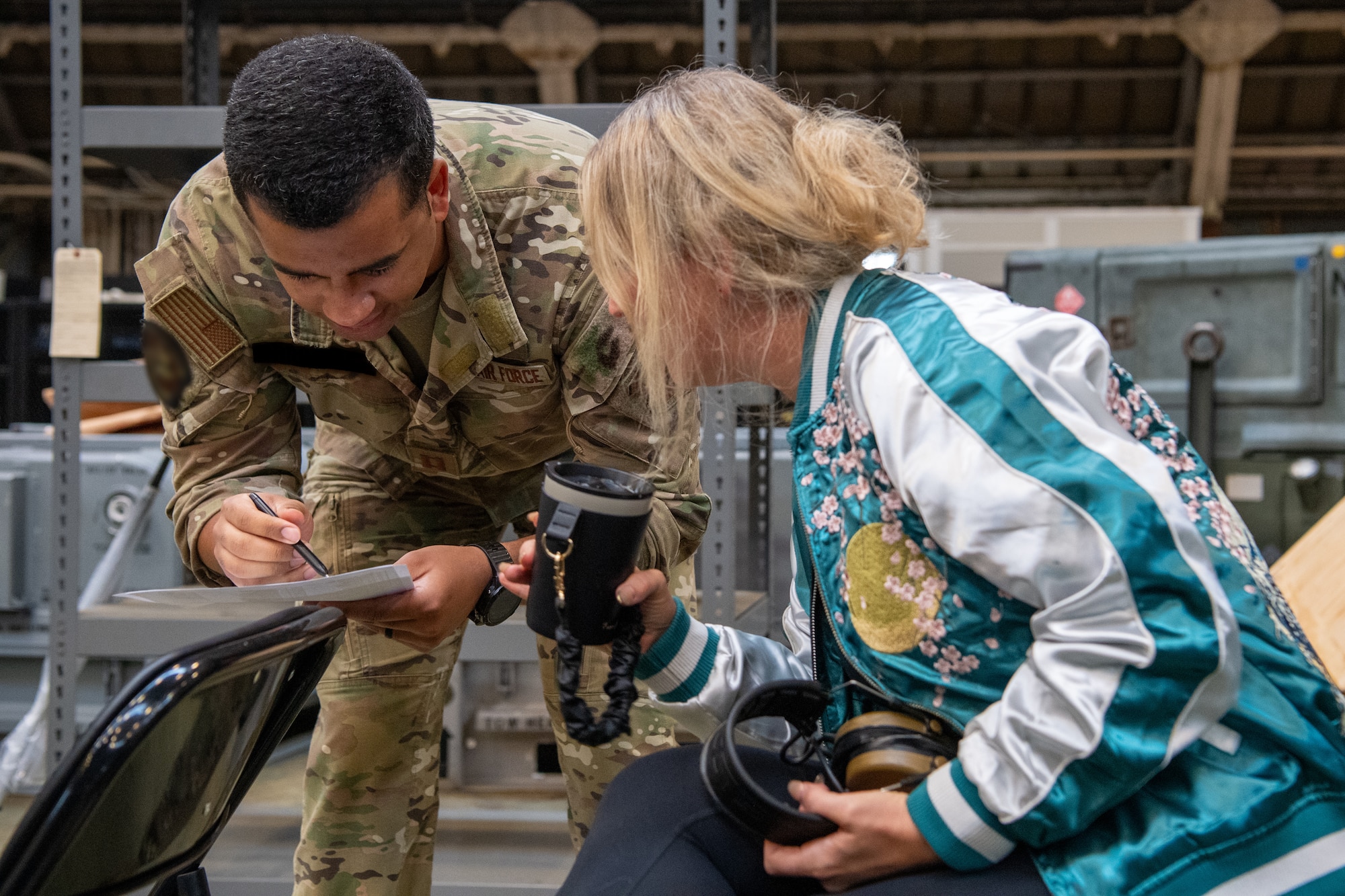 An Airman assigned to the 353rd Special Operations Wing reviews pre-flight guidance with a military spouse.