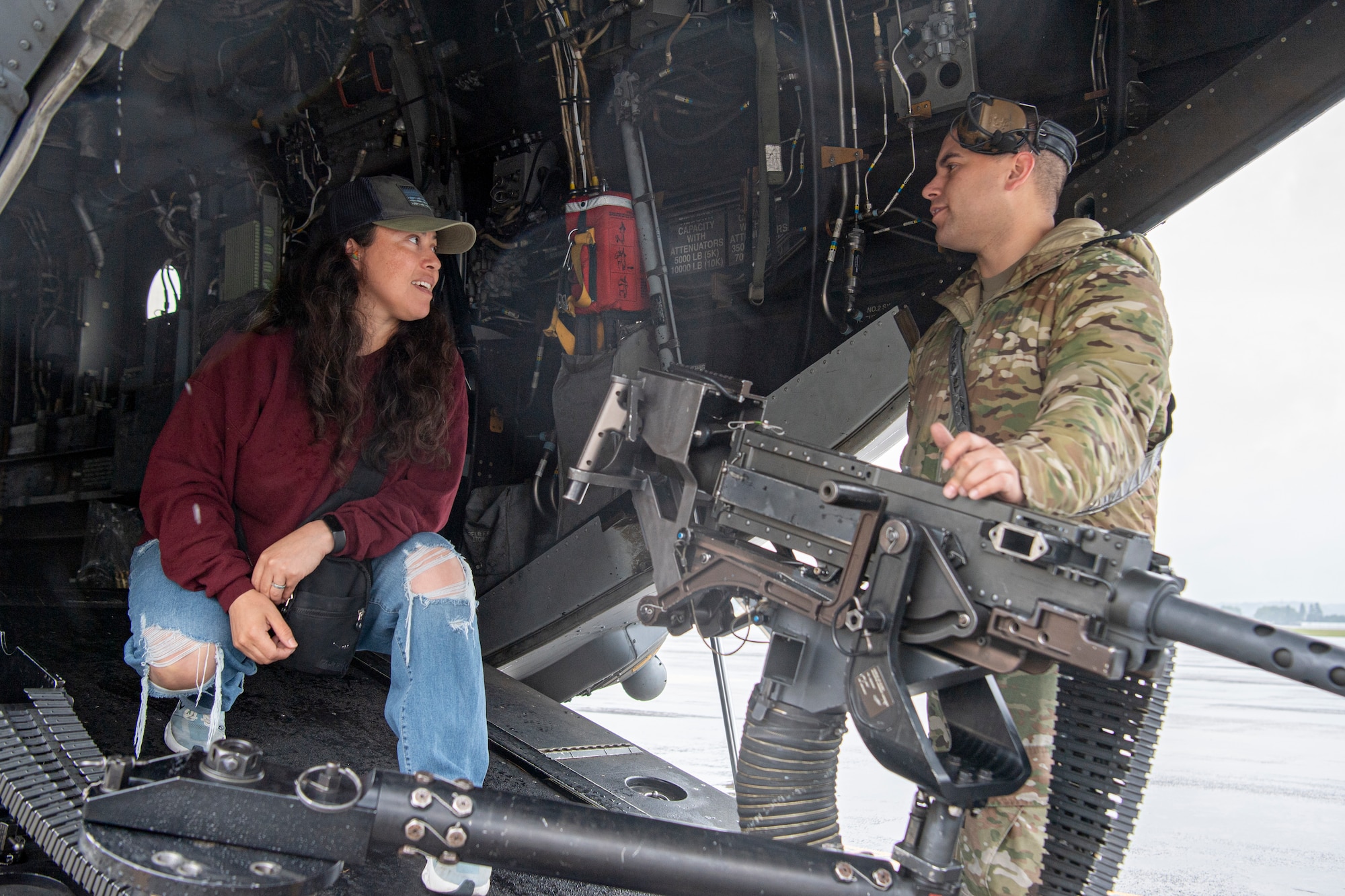 An Airman assigned to the 353rd Special Operations Wing showcases a GAU-21.50 caliber machine gun to a military spouse.