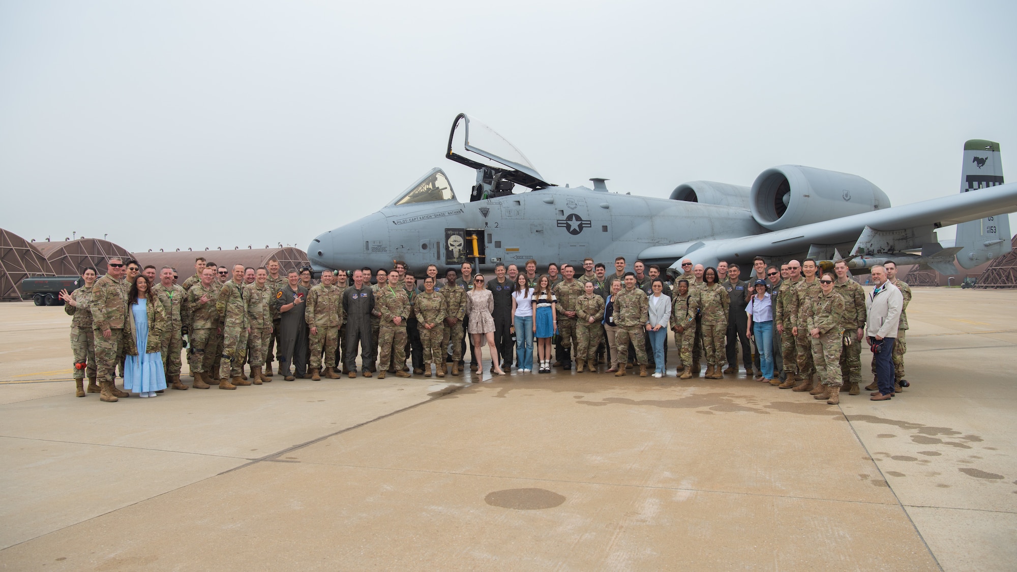 Team Osan members and family gather for a group photo in front of an A-10 Thunderbolt II to celebrate U.S. Air Force Col. William McKibban, 51st Fighter Wing commander, as he completes his fini flight at Osan Air Base, Republic of Korea, June 2, 2025.