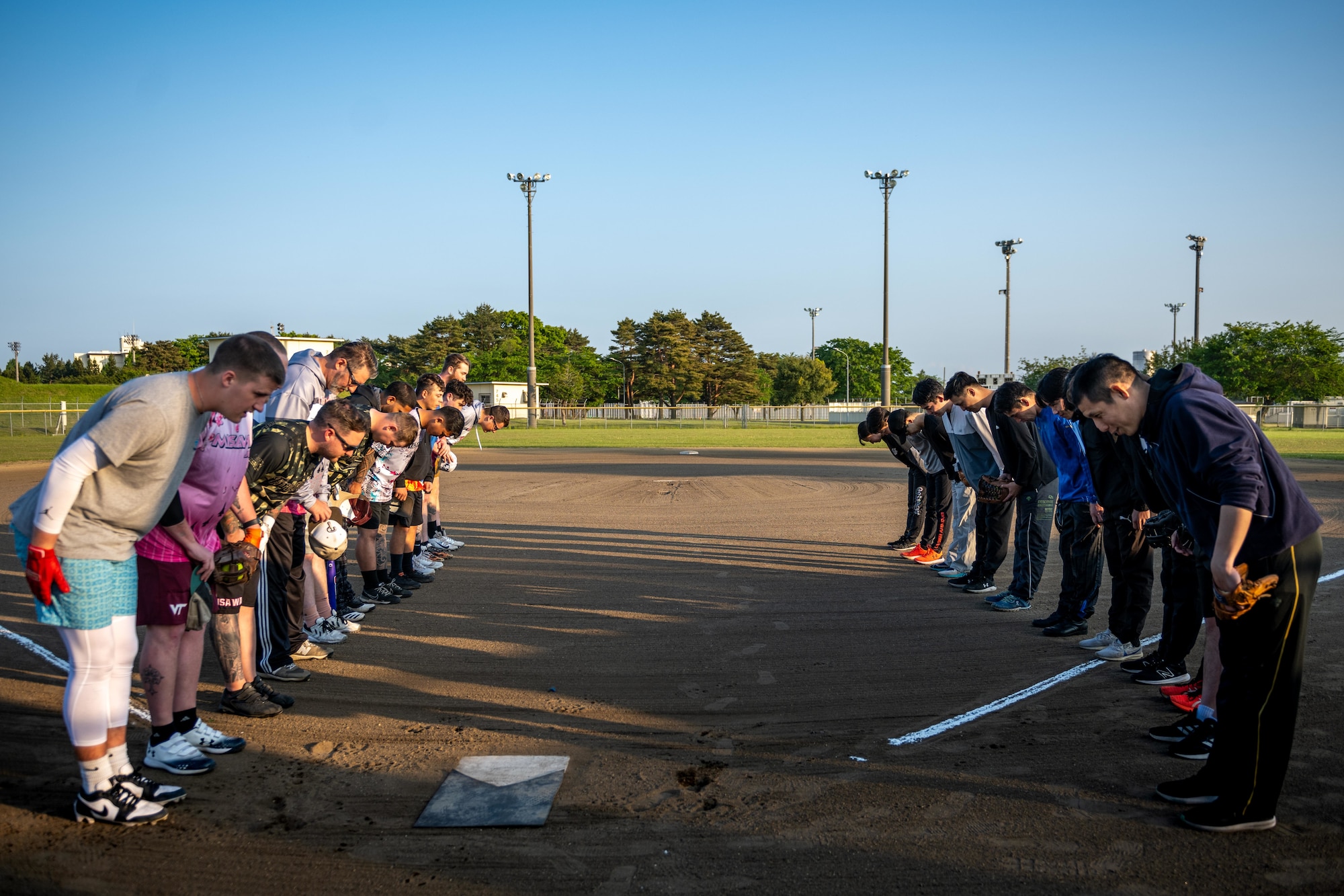 U.S. participants bow to Japanese participants before a game of softball as part of Sakura Olympics 2025.