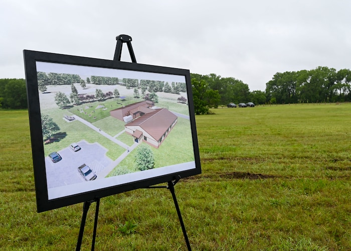A large poster with a rendering of a building with an outdoor fenced in area.