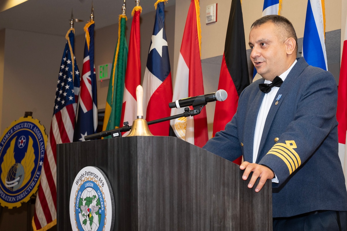 Greek military officer stands at podium.