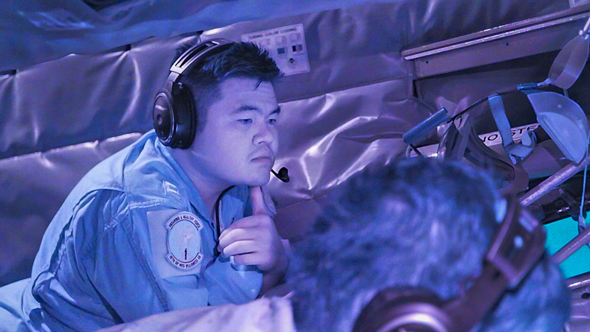 A U.S. Air Force Airman looks out a window.