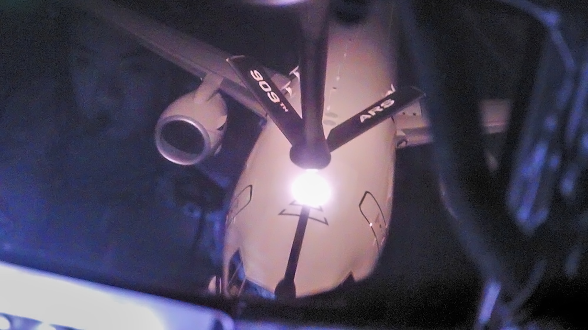 Two U.S. aircraft perform aerial refueling operations.