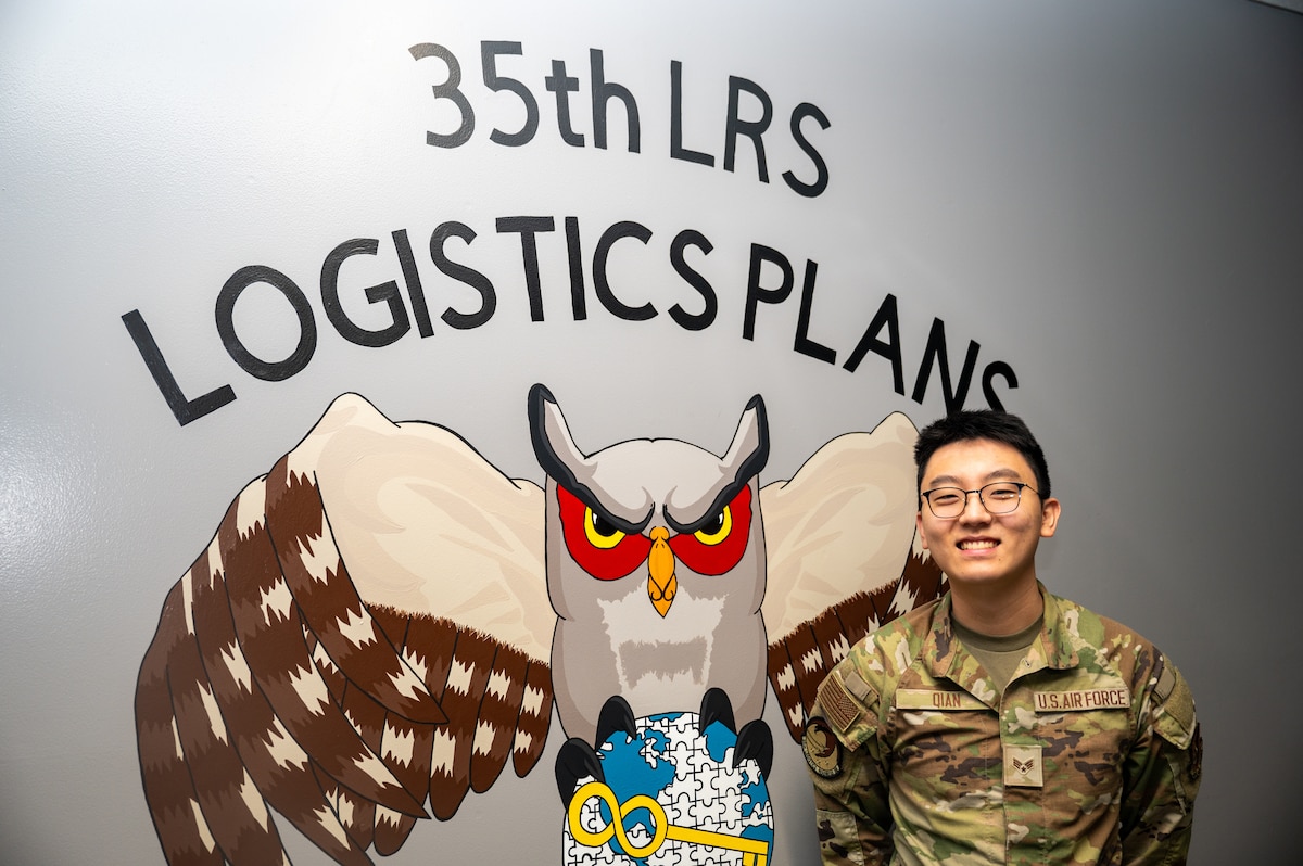 Wild Weasel of the Week (WWoW), U.S. Air Force Senior Airman Davis Qian, 35th Logistics Readiness Squadron (LRS) base support agreement manager, poses in front of a mural at his work center at Misawa Air Base, Japan, June 5, 2025.