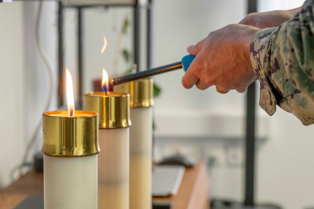 Capt. Stephen Steacy, commanding officer, Naval Support Activity (NSA) Souda Bay, lights a candle during a Memorial Day ceremony onboard NSA Souda Bay, Greece, on May 22, 2025.