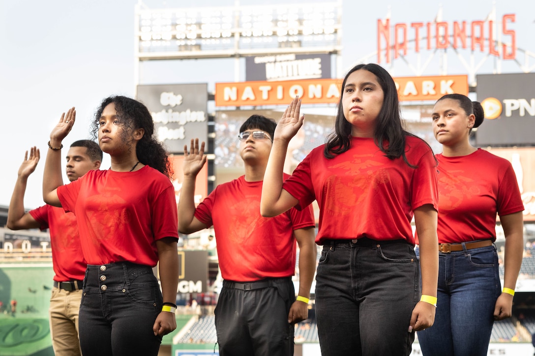 Poolees from Recruiting Station Baltimore conduct the Oath of Enlistment before the baseball game for Marine Day at the Nationals Park, Washington D.C., June 4, 2025. Marine Day is held to demonstrate unique Marine Corps capabilities, develop enduring relationships with our community, and showcase Esprit De Corps. (U.S. Marine Corps photo by Lance Cpl. Harleigh Faulk)