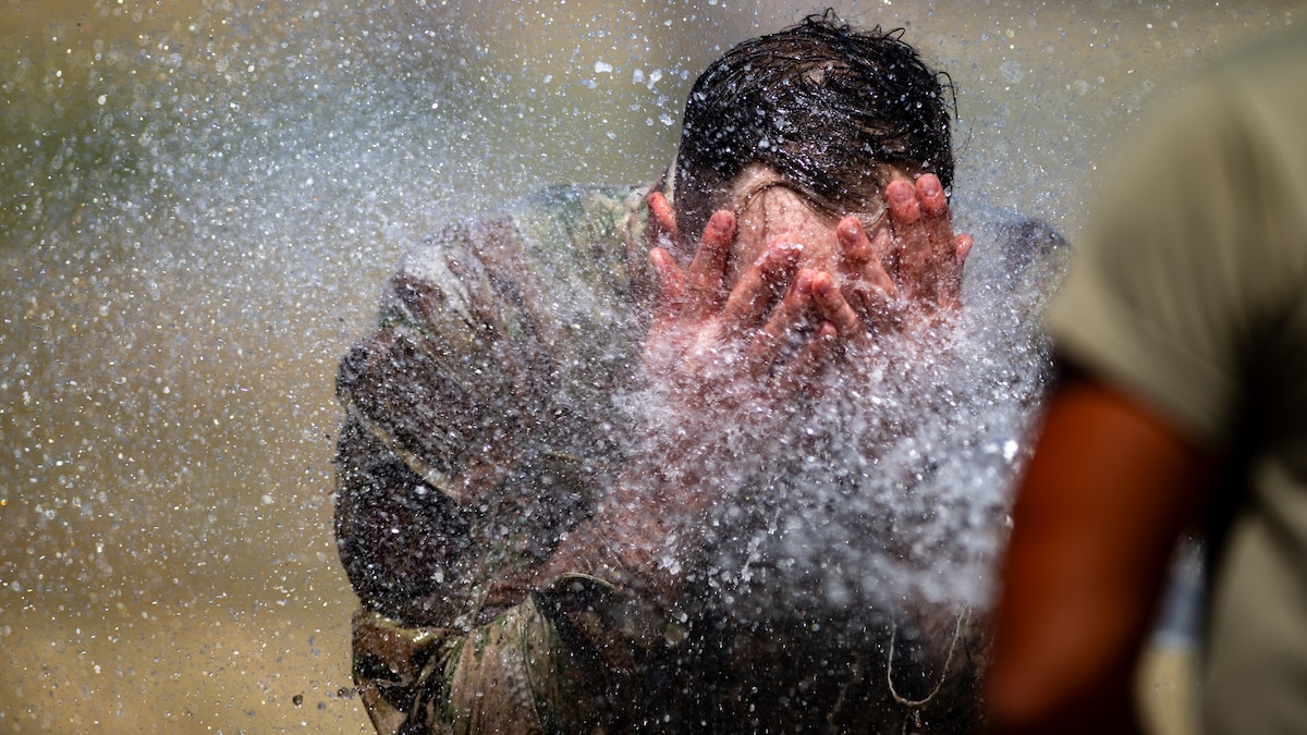 Senior Airman Tanner Trivers, 60th Medical Support Squadron biomedical equipment technician, washes his face after crawling through a mud pit during Warrior Readiness Day at Travis Air Force Base, Calif., May 22, 2025. The event was an opportunity to step away from the daily routine and reconnect with teammates through a series of obstacles, mental challenges and scenarios. (U.S. Air Force photo by Senior Airman Robert Nichols)