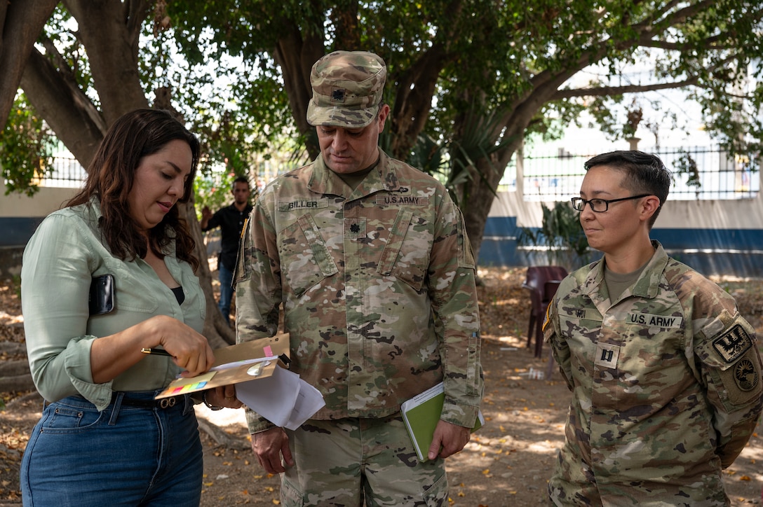 Anna Julia Flores, left, Comayagua governor, speaks with U.S. Army Lt. Col. Achim Biller, center, Joint Task Force-Bravo J9, Civil Affairs director, while Capt. Renelle Hui, JTF-Bravo surgeon cell medical planner, listens, during a medical mission in Comayagua, Honduras, May 29, 2025. Since 1992, JTF-Bravo has helped to improve overall public health in Central America, which is integral to long-term regional stability. (U.S. Air Force photo by Staff Sgt. Sadie Colbert)