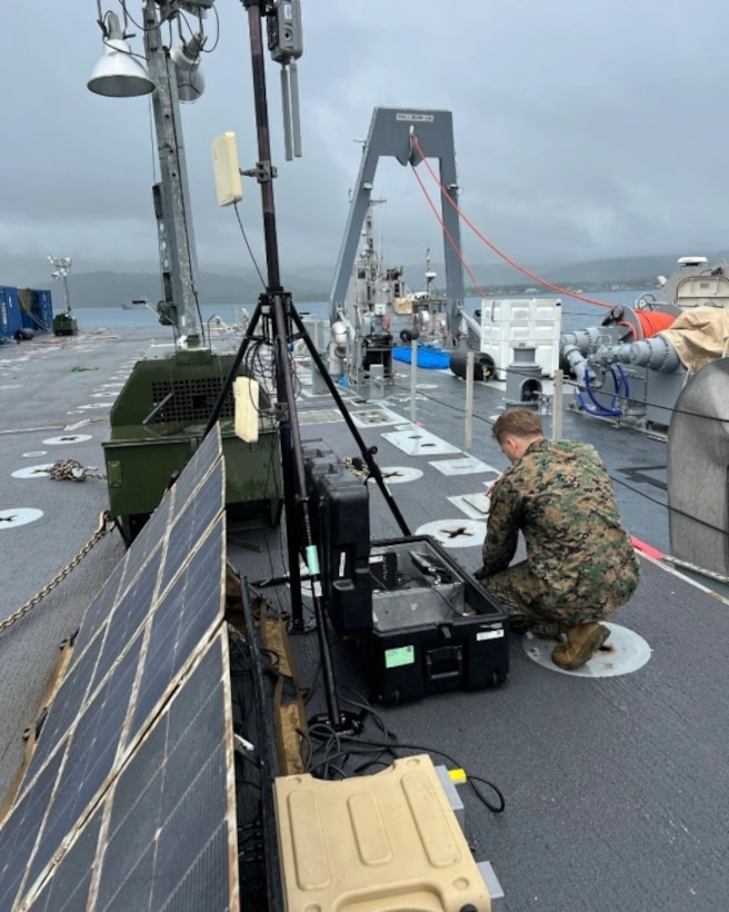 Marine wearing uniform on top of a ship using RFID technology scanners.