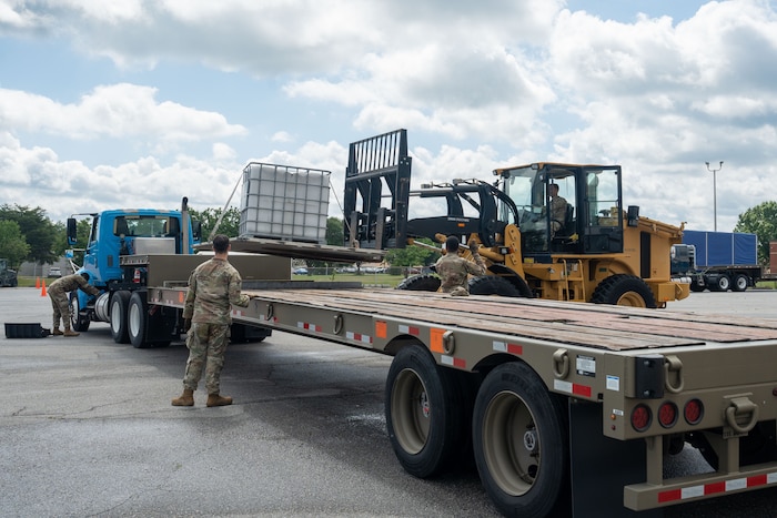 Airmen unload heavy equipment from a tractor trailer at Robins Air Force Base, Georgia, May 13, 2025.