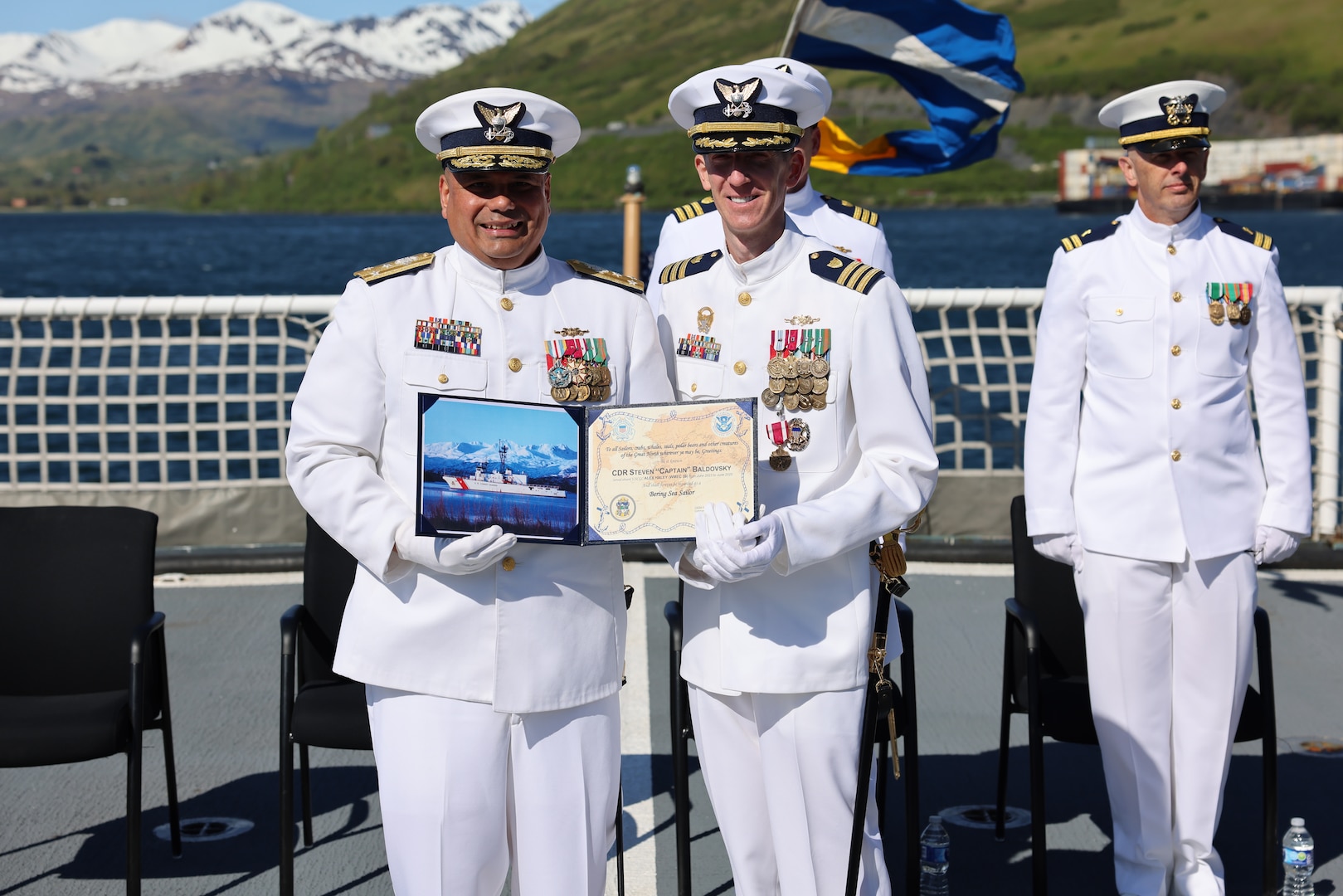 Cmdr. Steven Baldovsky, commanding officer, Coast Guard Cutter Alex Haley (WMEC-39) is presented with an award by Vice Adm. Andrew Tiongson, commander, Coast Guard Pacific Area, during the change of command ceremony for the Alex Haley in Kodiak, Alaska, June 5, 2025. Alex Haley is a 282-foot Medium Endurance Cutter that performs search and rescue, fisheries law enforcement, and maritime security. (U.S. Coast Guard photo by Lt. j.g. John Walsh).