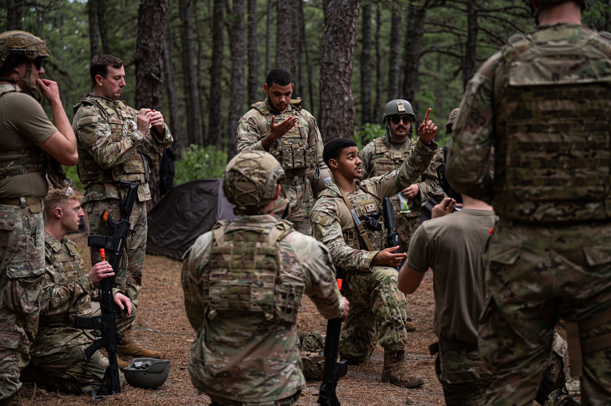U.S. Air Force Airmen attending the Kish Airman Leadership School, debrief after simulated drone and ground attacks on their encampment.