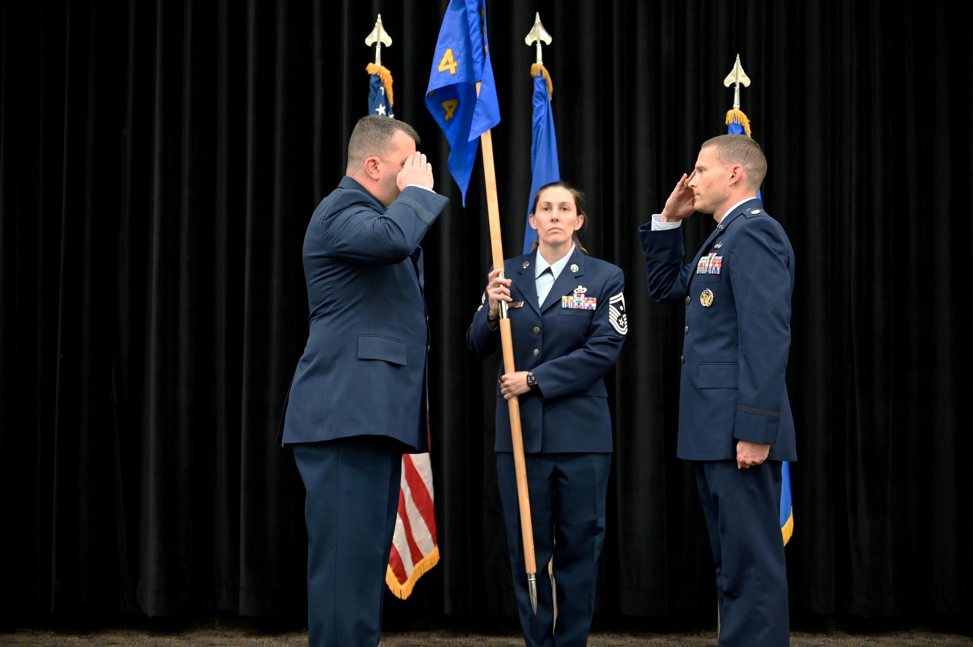 Airmen salute each other during a squadron activation ceremony.
