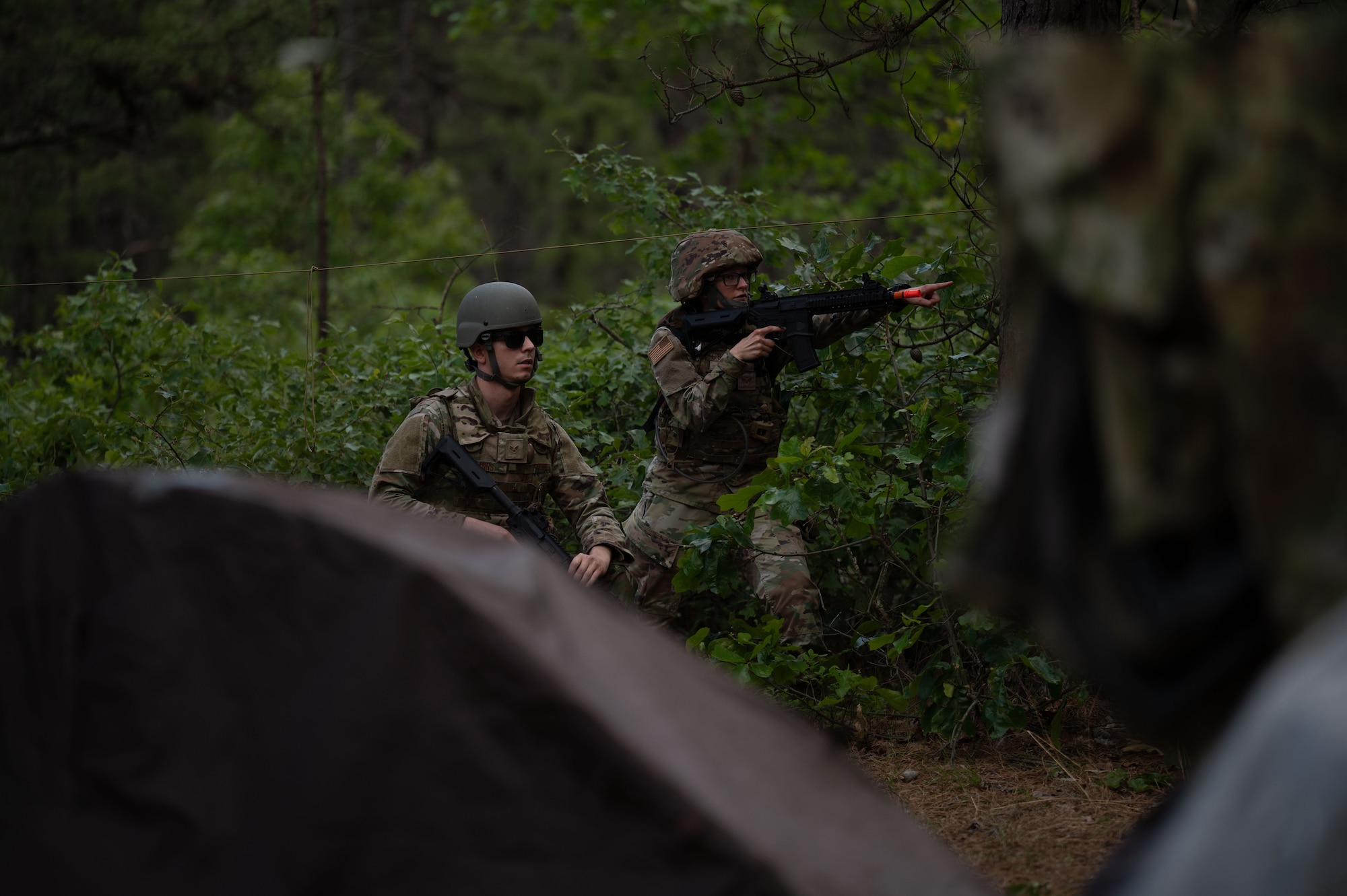 U.S. Air Force Senior Airman Cameron Mann, 305th Aircraft Maintenance Squadron C-17 electrical and environmental journeyman and Senior Airman Miranda Segrest, 87th Civil Engineer Squadron emergency management journeyman, defend their encampment from a simulated attack during a combative field exercise