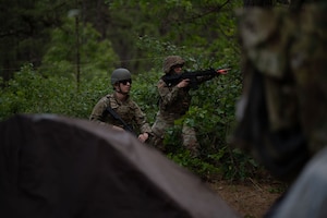 U.S. Air Force Senior Airman Cameron Mann, 305th Aircraft Maintenance Squadron C-17 electrical and environmental journeyman and Senior Airman Miranda Segrest, 87th Civil Engineer Squadron emergency management journeyman, defend their encampment from a simulated attack during a combative field exercise