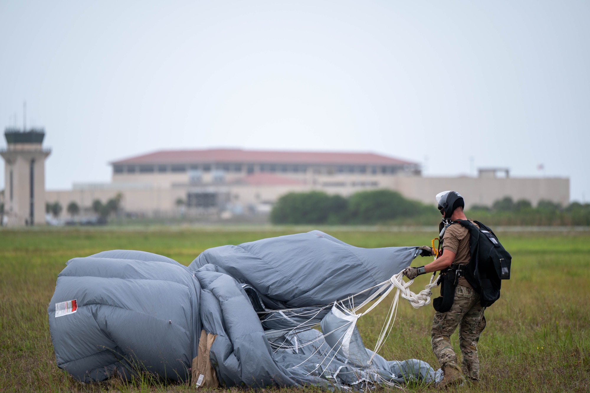A pararescue specialist packs up his parachute