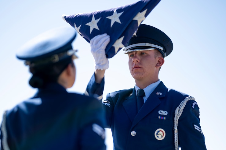 U.S. Air Force Airman 1st Class Even Weller, 49th Force Support Squadron Steel Talons Honor Guard member, dresses the American Flag during a Memorial Day ceremony at Holloman Air Force Base, New Mexico, May 22, 2025. 