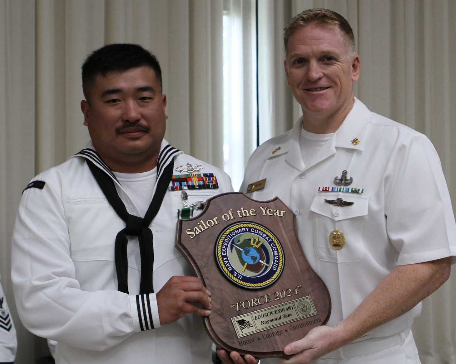 Equipment Operator First Class Raymond Tam, assigned to Naval Mobile Construction Battalion 4, is awarded Navy Expeditionary Combat Command's Fiscal Year 2024 Sailor of the Year by Force Master Chief Eric Neal, Navy Expeditionary Combat Command.