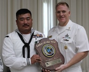 Equipment Operator First Class Raymond Tam, assigned to Naval Mobile Construction Battalion 4, is awarded Navy Expeditionary Combat Command's Fiscal Year 2024 Sailor of the Year by Force Master Chief Eric Neal, Navy Expeditionary Combat Command.