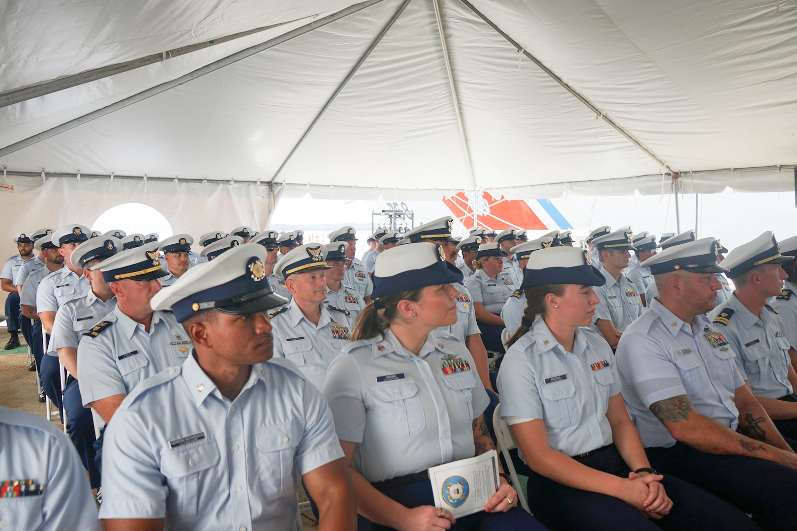 The crew of Coast Guard Cutter Stone (WMSL 758) listens to Capt. Jonathan Carter, outgoing commanding officer of Stone, deliver his remarks during the cutter's change-of-command ceremony in North Charleston, South Carolina, June 5, 2025. Capt. Anne O’Connell relieved Carter as the fourth commanding officer of Stone during the ceremony, which was presided over by Vice Adm. Nathan A. Moore, commander, Coast Guard Atlantic Area. (U.S. Coast Guard photo by Ensign Sarah Pearson)