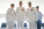 Capt. Anne O’Connell, incoming commanding officer of Coast Guard Cutter Stone (WMSL 758), Vice Adm. Nathan Moore, commander, Atlantic Area, and Capt. Jonathan Carter, outgoing commanding officer of Stone, pose for a photo while Senior Chief Petty Officer Emerio Labori, Stone's command senior enlisted leader, looks on during the cutter's change-of-command ceremony in North Charleston, South Carolina, June 5, 2025.  O'Connell is the fourth commanding officer of the 418-foot, Legend-class national security cutter. (U.S. Coast Guard photo  by Ensign Sarah Pearson)