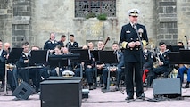 dm. Stuart B. Munsch, commander of U.S. Naval Forces Europe (NAVEUR), speaks to a crowd of military members, veterans and civilians at Sainte-Mère-Église Church in Sainte-Mère-Église, France during the United in Our Victory NAVEUR Band concert.