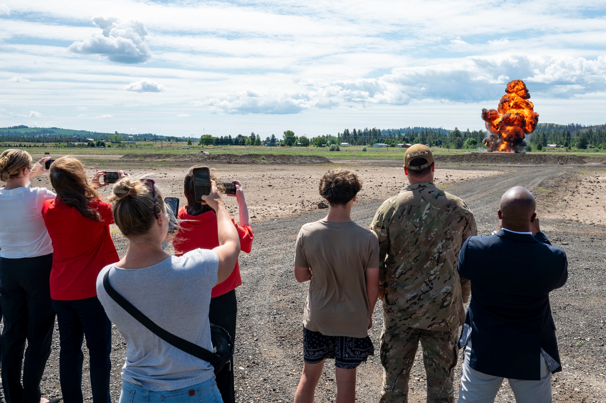 A group of people watch a controlled detonation.