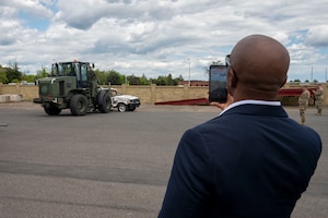 A man takes a video of a forklift.