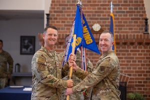 U.S. Air Force Maj. James Barrett receives the guidon from Col. Kenneth Roberts, 23rd Mission Support Group commander, assuming command of the 23rd Contracting Squadron, during a change of command ceremony at Moody Air Force Base, Georgia, June 6, 2025. The passing of the guidon is a military tradition signifying the change of authority and responsibility of a unit from one commander to another. (U.S. Air Force photo by Airman 1st Class Iain Stanley)